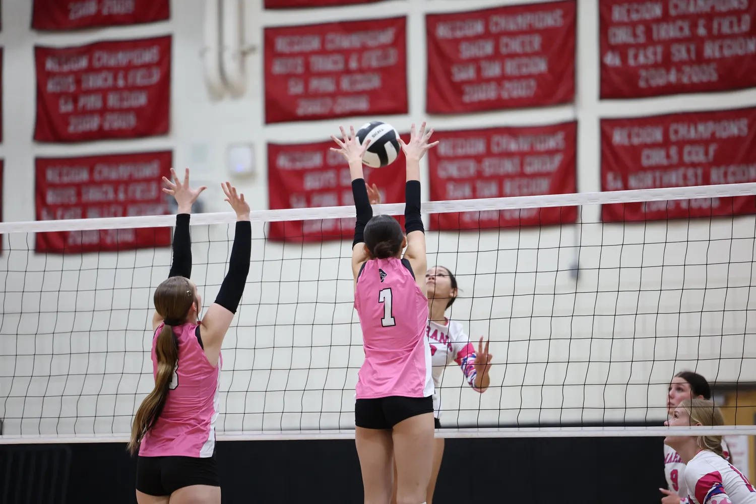 Girls Volleyball Teammates blocking the ball